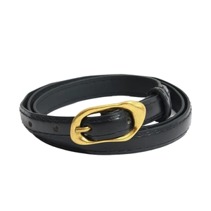 Ceinture fine en cuir noir pour femme avec boucle dorée ovale vintage sur fond blanc