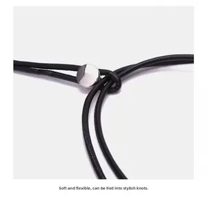 Détail d'un cordon de taille noir souple en cuir avec une boucle métallique argentée