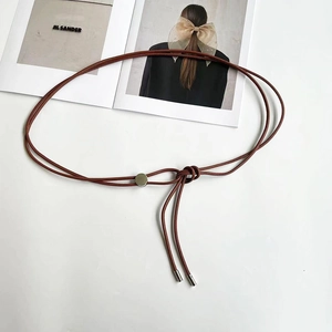 Détail des cordes en cuir tressé rouge brique avec boucle de réglage en métal argenté