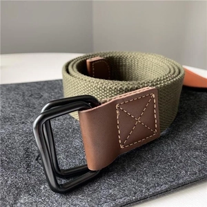 Close-up van militaire groene canvas riem met zwarte dubbele D-ring gesp en lederen punt