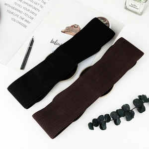 Detail of wide elastic waist belts in black and brown with vintage round metal buckles