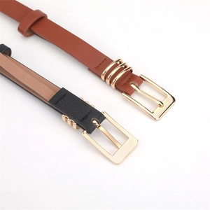Detail of brown and black leather belts featuring elegant golden square metal buckles