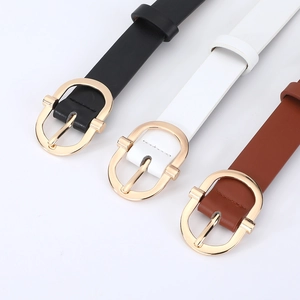 Gros plan sur des ceintures en cuir noir, blanc et marron avec boucles ovales dorées