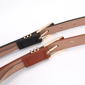 Close-up of black and brown leather belts with gold metal rings and needle buckles