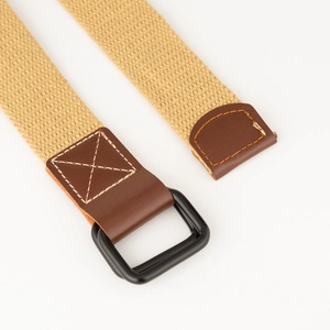 Detailopname van kaki canvas riem met zwarte dubbele D-ring gesp en lederen uiteinden