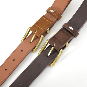 Detail of vintage square gold buckle with brown leather and suede stitching texture