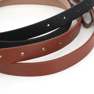 Close-up of faux leather belts with gold pin buckle showing texture and hole details