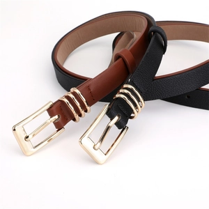 Detail of slim black and brown faux leather belts with golden three-ring pin buckles