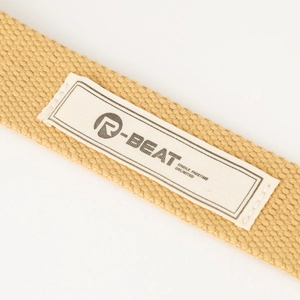 Detailweergave van beige canvas riem met R-BEAT geweven label en precisie stikwerk