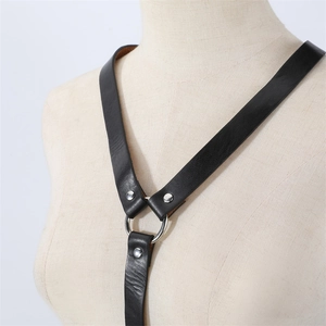 Détail d'un harnais de corps en cuir noir style punk avec anneau en O et rivets argentés