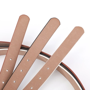 Gros plan sur ceinture en cuir marron avec perforations précises et bords contrastés