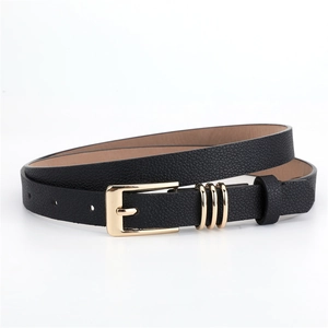 Close-up of black leather belt featuring a polished gold buckle and three decorative rings