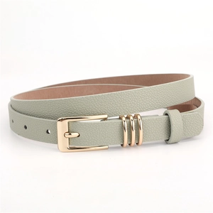 Close-up of sage green faux leather belt with golden pin buckle and decorative rings