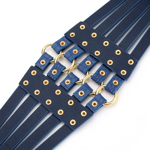 Détail de la ceinture multicouche en cuir bleu foncé avec anneaux métalliques dorés