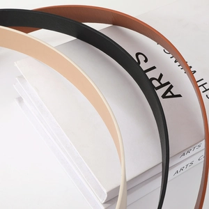 Close-up of minimalist slim leather belts in khaki, black, and brown with gold buckle