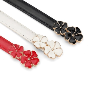 Detail of adjustable skinny belts with dual flower buckles in black, white, and red colors