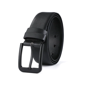 Détail de la boucle en métal noir mat et de la texture quadrillée fine sur la ceinture homme