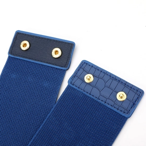 Détail de la ceinture élastique bleue avec cuir crocodile et boutons-pression dorés