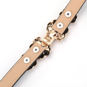 Detail of golden floral metal buckle and beige leather lining with reinforced screws