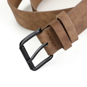Gros plan d'une ceinture en cuir marron vintage avec boucle ardillon noire mate et grainée