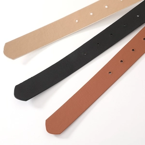 Detail of black, brown and beige leather belts with polished adjustment holes