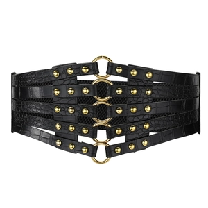 Détail d'une ceinture corset noire en cuir crocodile avec anneaux et rivets dorés
