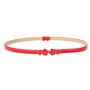 Detail of red patent leather skinny belt with floral metal buckle for dresses