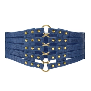 Détail d'une ceinture corset bleu foncé avec cuir croco et anneaux dorés en métal