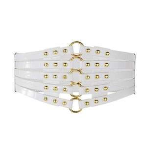 Détail d'une ceinture corset blanche à motif crocodile et anneaux métalliques dorés