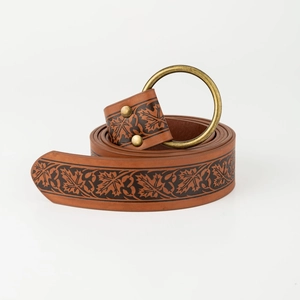 Detail of vintage brown leather belt with embossed maple leaf patterns and brass buckle