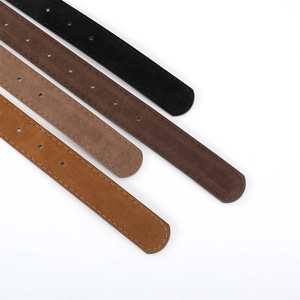 Close-up of faux suede belt tails in black, brown, and camel with detailed stitching