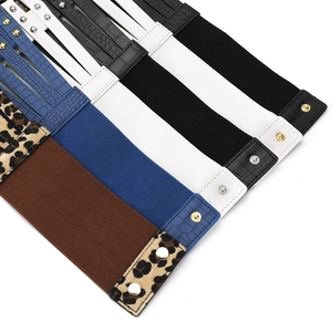 Détail de plusieurs ceintures élastiques larges avec motifs léopard et textures croco
