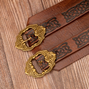 Detail of vintage brown leather armor with Celtic knot embossing and bronze buckles