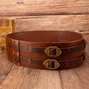 Detail of vintage medieval brown leather belt with Celtic knot embossing and twin buckles
