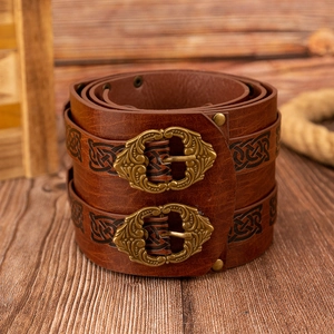 Detailed macro of vintage brown leather arm guard with Celtic knot and bronze buckles