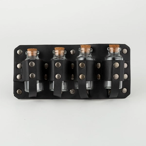 Detail of vintage medieval leather belt with bronze rivets and four glass potion bottles