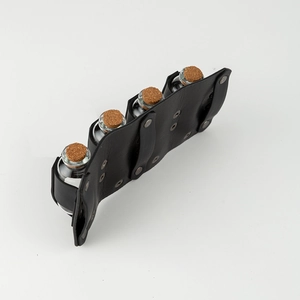 Detail of four medieval glass potion bottles with corks in a black leather belt holder