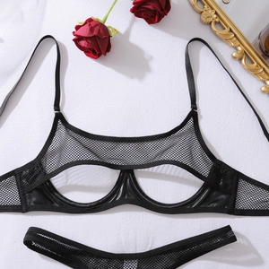 Flat lay of black mesh lingerie set with cut-out details and red roses on white fabric