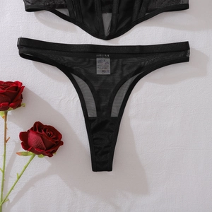 Détail d'un ensemble de lingerie en résille noire avec étiquette d'entretien du tissu