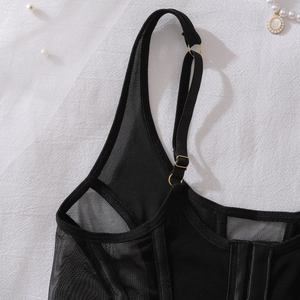 Détail d'un corset en mesh noir avec attaches dorées réglables et fermeture à crochets