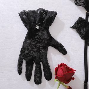 Detailansicht der schwarzen Spitzenhandschuhe mit Blumenstickerei und Sternanhänger