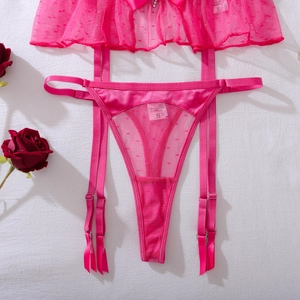Dettaglio del set di lingerie in pizzo rosa con giarrettiere e fiocchi in raso