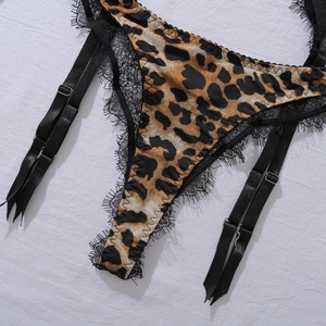 Close-up of leopard print fabric with delicate black eyelash lace and adjustable straps