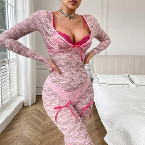 Détail du body en dentelle rose avec bordures magenta et petits nœuds décoratifs élégants