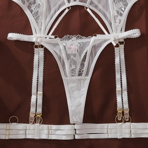 Detailed macro shot of white lace embroidery with gold metal adjusters and clips