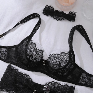Detailed macro shot of black lace lingerie set featuring an oval gem and underwire cups