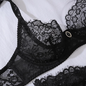 Close-up of black floral lace bra featuring eyelash trim and a centered crystal gemstone