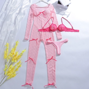 Vue détaillée de la dentelle florale rose avec de délicats nœuds sur un ensemble trois pièces