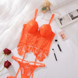 Detailed flat lay of orange lace corset lingerie set with floral embroidery and accessories