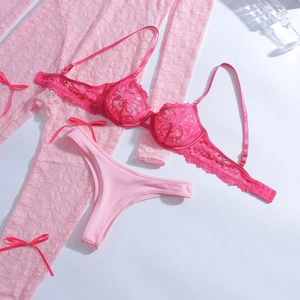 Détail de l'ensemble de lingerie trois pièces en dentelle aux motifs floraux roses